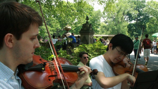 Violinists perform duets in Central Park on Memorial Day.